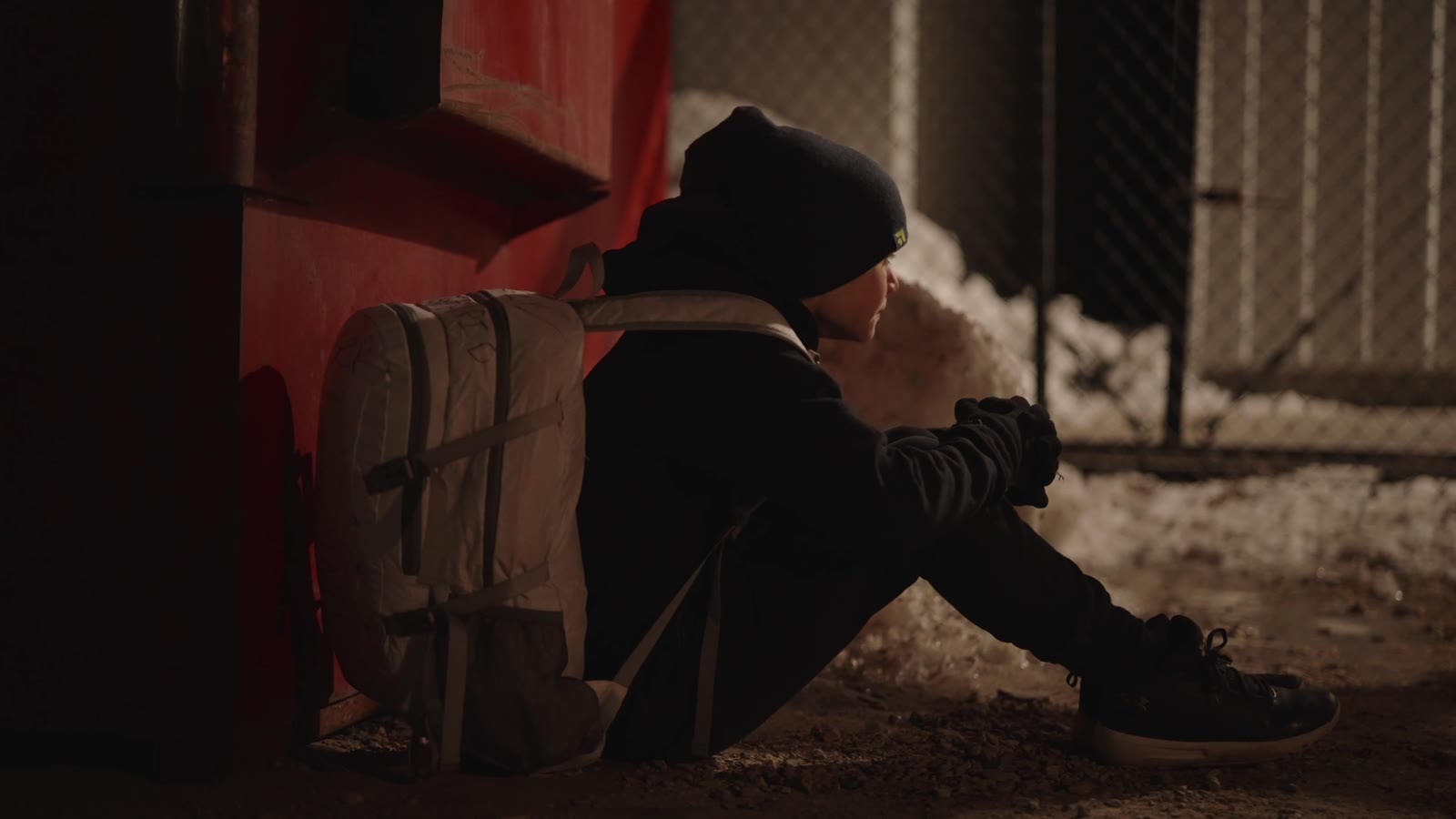 A boy sitting on the ground in the dark, from the Not Afraid of the Dark film